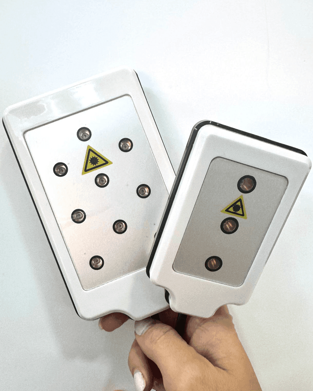Due placche PAD Lipolaser di Infinity 360° tenute in mano, da otto e da tre diodi